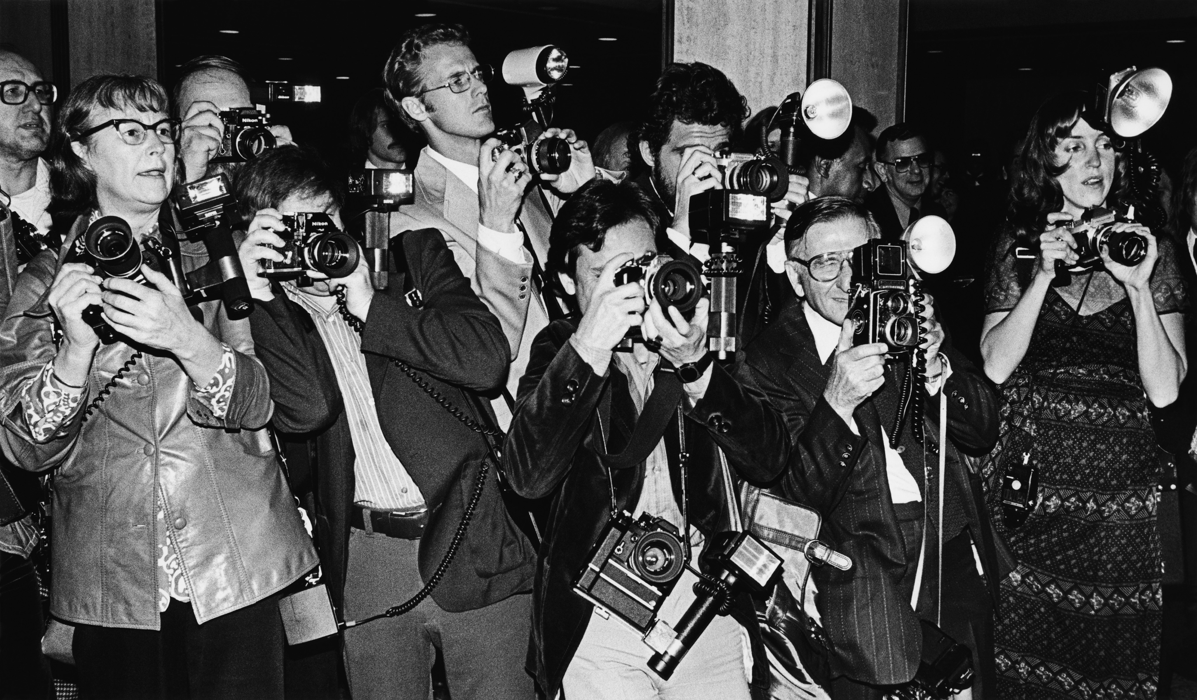 Paparazzi photographers crowded on a New York City sidewalk